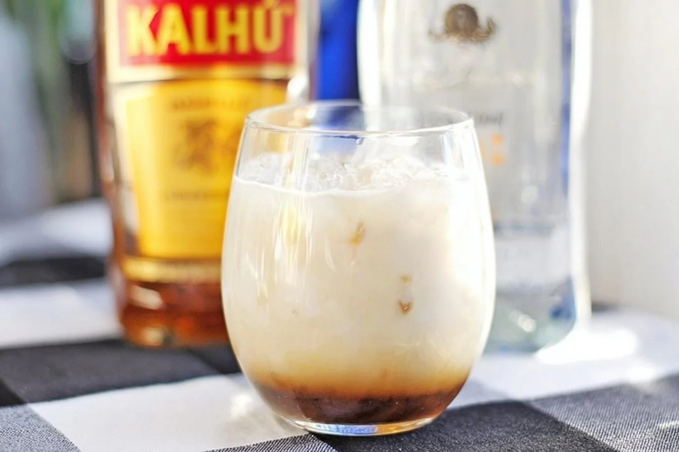 Delicious White Russian cocktail in a glass with cream and coffee liqueur