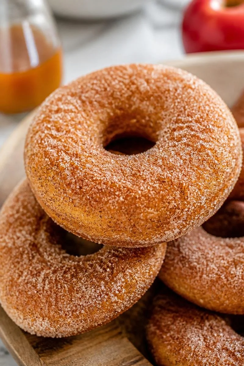 Baked cinnamon sugar apple cider donuts on a wooden table