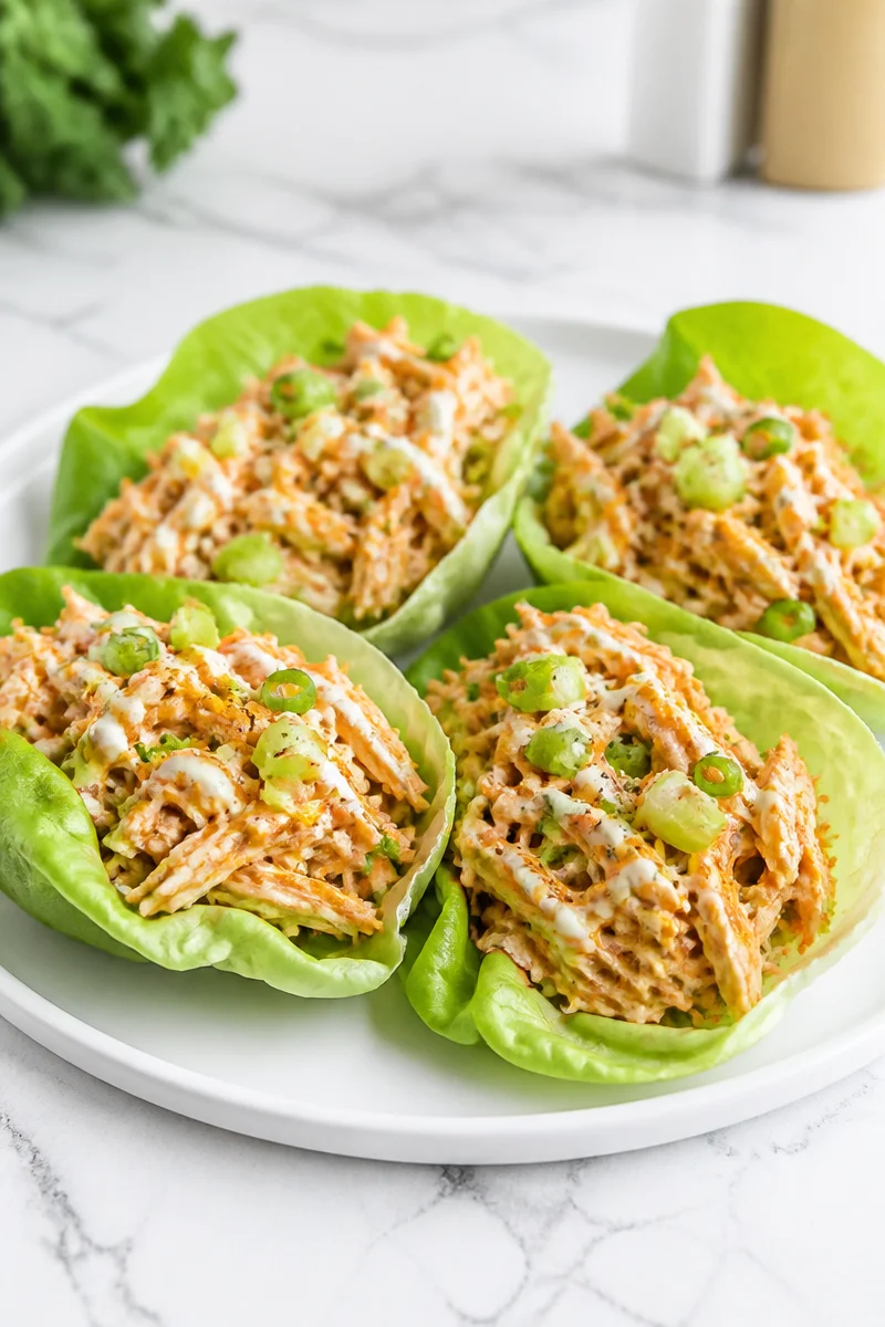 Buffalo Chicken Salad Lettuce Wrap on a plate with fresh ingredients.